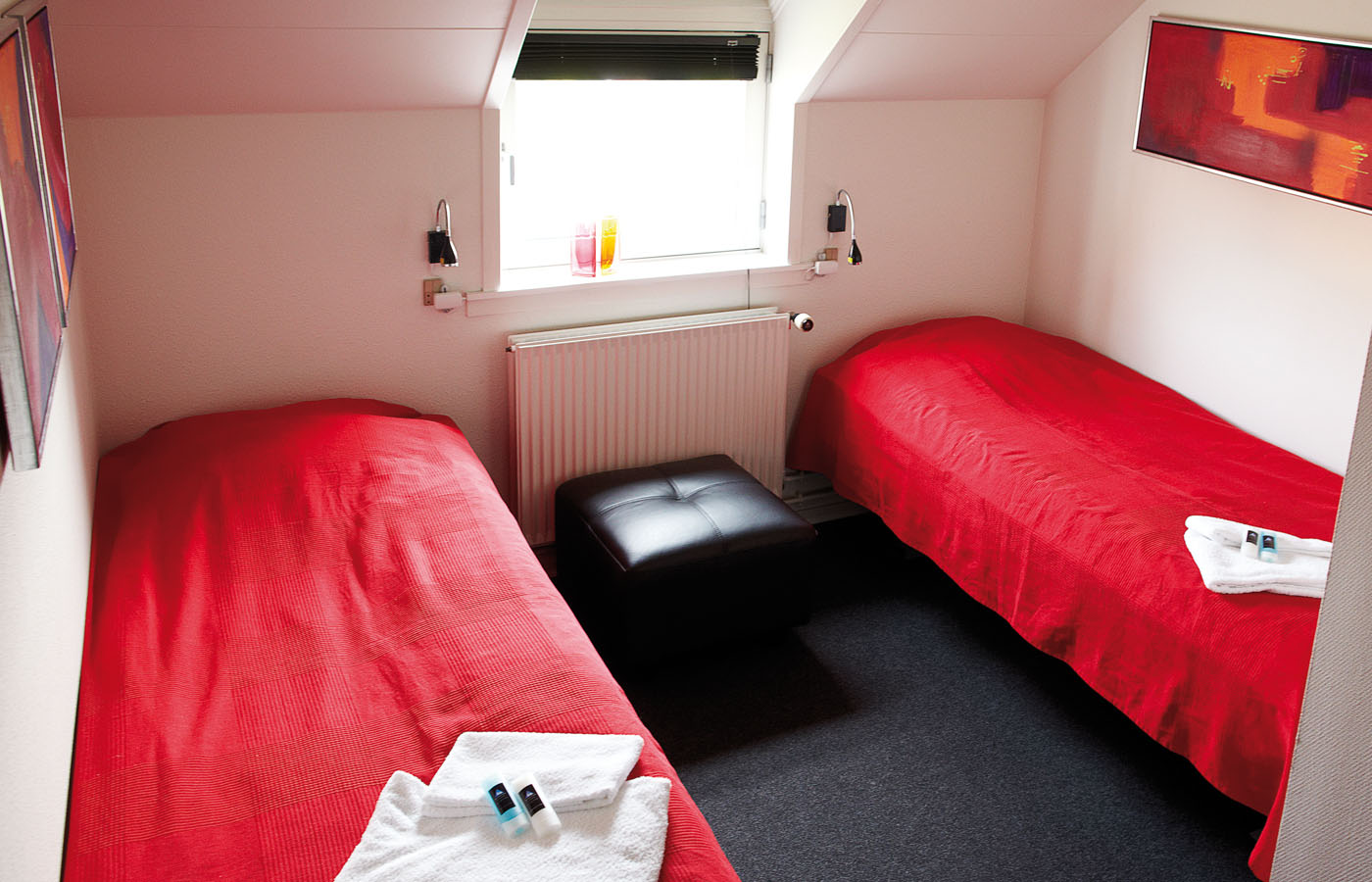 værelse med senge og sengelamper som kan benyttes når du overnatter I Svendborg